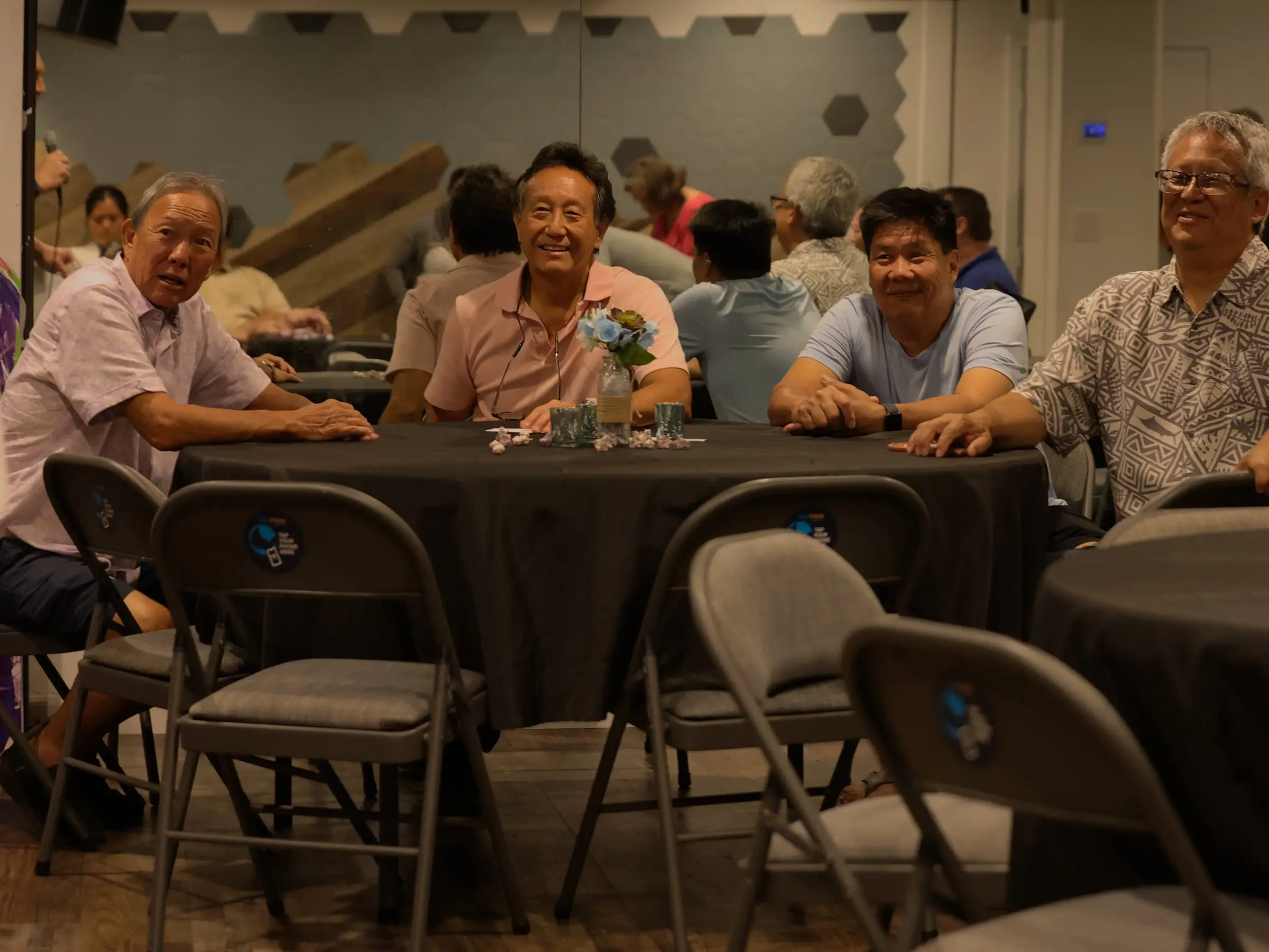 Four men laughing together around a table at the Ministry Center